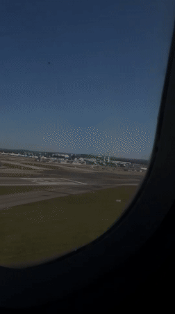 Passenger films airport view from airplane window over Crawley
