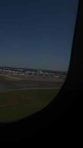Passenger films airport view from airplane window over Crawley