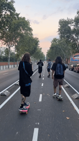 Four skaters cruise a Barcelona street at sunset