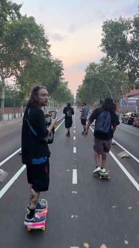 Four skaters cruise a Barcelona street at sunset