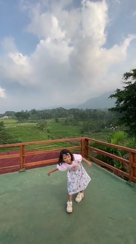 Family visits Indonesian rice terrace viewing platforms, dines outdoors