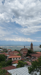 Tourist explores historic Sighnaghi, Georgia capturing scenic town views