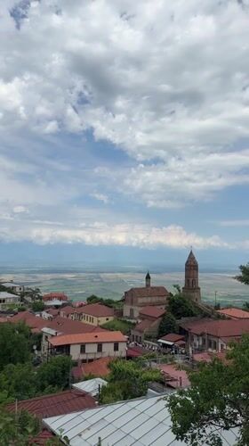 Tourist explores historic Sighnaghi, Georgia capturing scenic town views