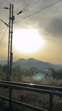 Train passenger films sunny mountain scenery, bird on powerlines