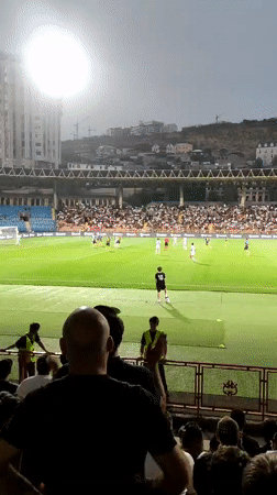 Nighttime football match, packed stadium, multiple angles