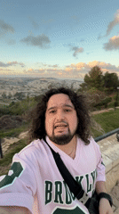 Tourist records selfie video from Jerusalem overlook during golden hour