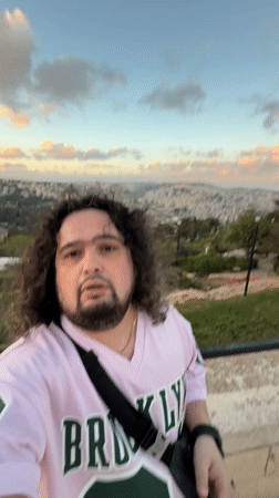 Tourist records selfie video from Jerusalem overlook during golden hour