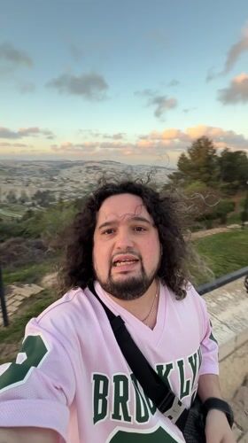 Tourist records selfie video from Jerusalem overlook during golden hour