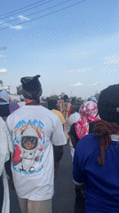 Crowd processes through Lokoja streets in mixed traditional, casual dress