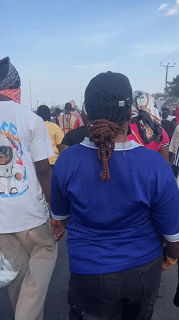 Crowd processes through Lokoja streets in mixed traditional, casual dress