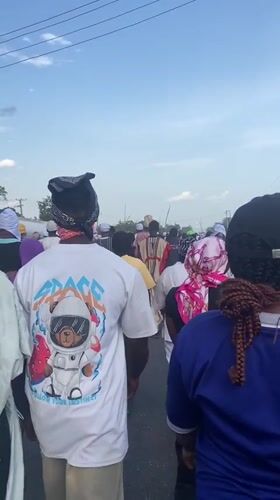 Crowd processes through Lokoja streets in mixed traditional, casual dress