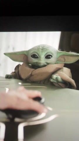 A green, alien-looking puppet with large ears and eyes, often referred to as Baby Yoda or Grogu, is shown from the chest up on top of a light-colored surface, possibly a table. A hand is seen in the foreground. The next shot shows the CASFILM Ltd logo in silver on a black background.