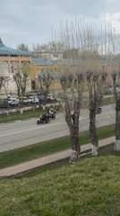 Flag-bearing motorcyclists parade through Russian town amid street life