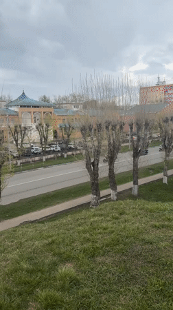 Flag-bearing motorcyclists parade through Russian town amid street life