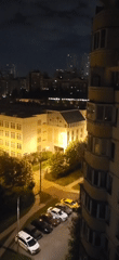 Nighttime urban park and illuminated building captured from above