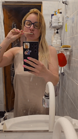 Woman brushes teeth while filming herself in Sochi bathroom
