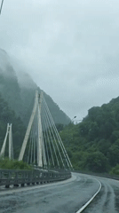 Vehicle crosses cable-stayed bridge in rainy conditions, Kepsha Russia