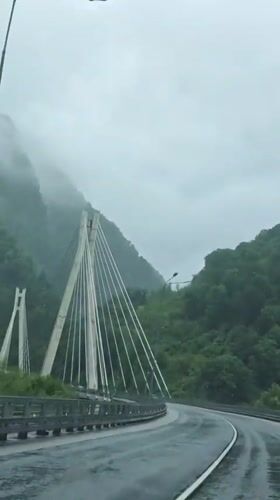 Vehicle crosses cable-stayed bridge in rainy conditions, Kepsha Russia