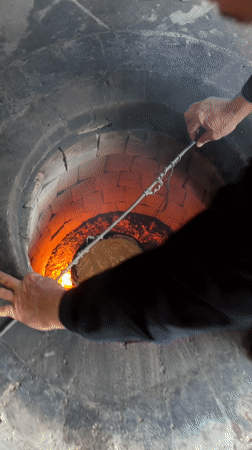Traditional tandoor oven in operation in Arshaluys, Armenia