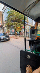 Auto-rickshaw passenger documents busy Bengaluru street scene