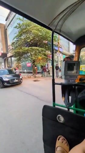 Auto-rickshaw passenger documents busy Bengaluru street scene