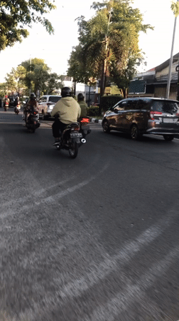 Busy afternoon motorcycle traffic across Larangan streets