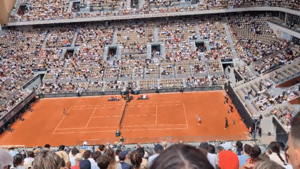 Tennis match underway at packed Paris clay court stadium