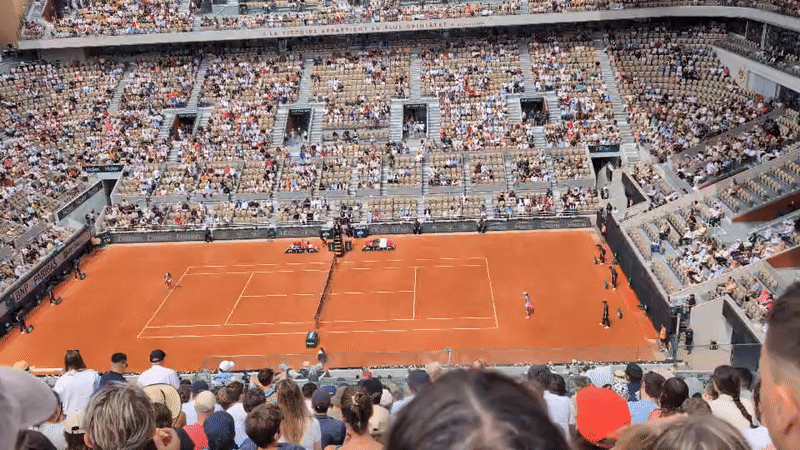 Tennis match underway at packed Paris clay court stadium