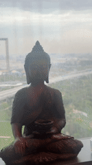 Buddha statue overlooks Dubai highway from window perch