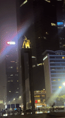 Jakarta monument observed at night amid urban skyscrapers