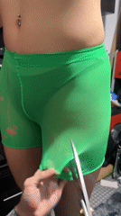 Two people modify mesh shorts with scissors in Sofia