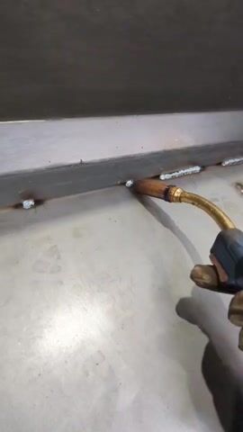 This media file depicts a close-up, first-person perspective of someone welding metal. The scene is set in an industrial or workshop environment, with a concrete floor and a metallic surface being worked on. The primary object is a welding torch, held by a gloved hand, emitting a bright arc and numerous sparks as it fuses metal.

The activity is welding, characterized by intense light, a shower of sparks, and likely the sound of the welding process. The metallic surfaces being joined appear to be part of a larger structure. The lighting is dominated by the brilliant white and blue glow of the welding arc, which creates a high-contrast scene with deep shadows. The sparks are orange and yellow, flying outwards in a radial pattern.

Notable details include the protective glove worn by the welder, suggesting a focus on safety. The bright, energetic nature of the welding process is visually striking. There are no discernible clues about the time of day or weather. The location is specified as Wieluń, Poland, which provides geographical context but doesn't offer visual cues within the frame itself. No text is visible in the media file. The overall impression is one of focused manual labor and the creation of a strong metal bond through intense heat and light.