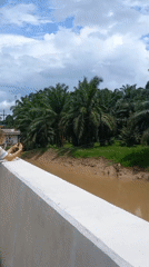 Woman photographs rural waterway scenery in Na Nuea, Thailand