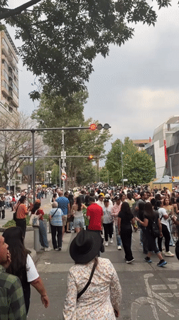 Evening pedestrian crossing captured near decorated Banamex building Mexico City