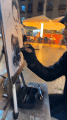 Street artist draws caricature in Barcelona plaza at night