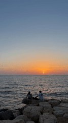 Couple sits by waterfront in Tel Aviv afternoon