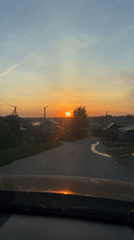 Vehicle travels through Chaikovsky village at sunset