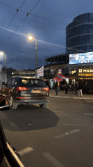 People gather with banners on Belgrade street at dusk