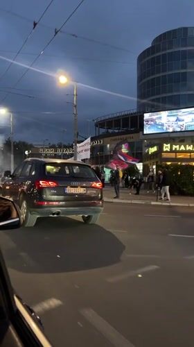 People gather with banners on Belgrade street at dusk