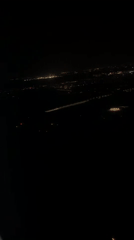 Airplane passenger films night city lights over Kastrup, Denmark