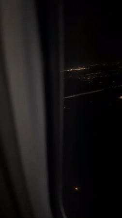 Airplane passenger films night city lights over Kastrup, Denmark