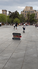 Skateboarder clears a three-board stack in Barcelona plaza