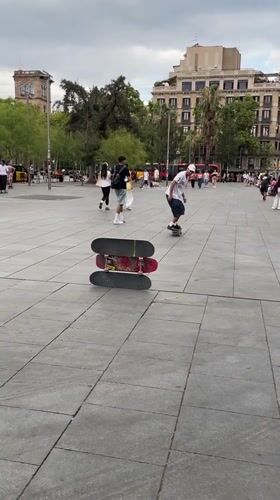 Skateboarder clears a three-board stack in Barcelona plaza