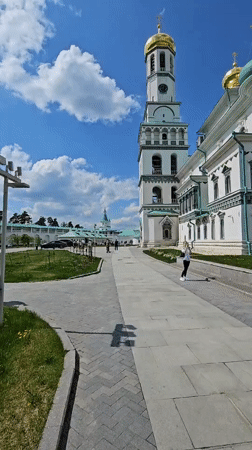Woman walks near gold-domed building in Istra, Russia
