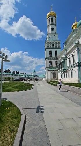Woman walks near gold-domed building in Istra, Russia