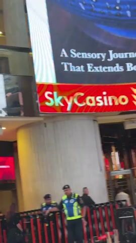 Here is a description of the video.

The video shows the exterior of SkyCasino. Several security guards stand behind barricades. Above the entrance to the casino is a large video screen that advertises SkyCasino with images of food and drinks.