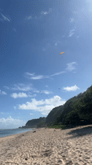 Paragliders soar over Kuta Selatan beach on sunny morning