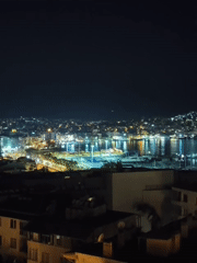 Drinks with a view over Kuşadası's lit-up marina at night.