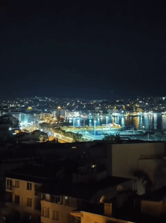 Drinks with a view over Kuşadası's lit-up marina at night.