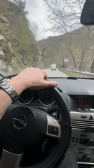 Driver navigates mountain road in Opel near Bachkovo, Bulgaria